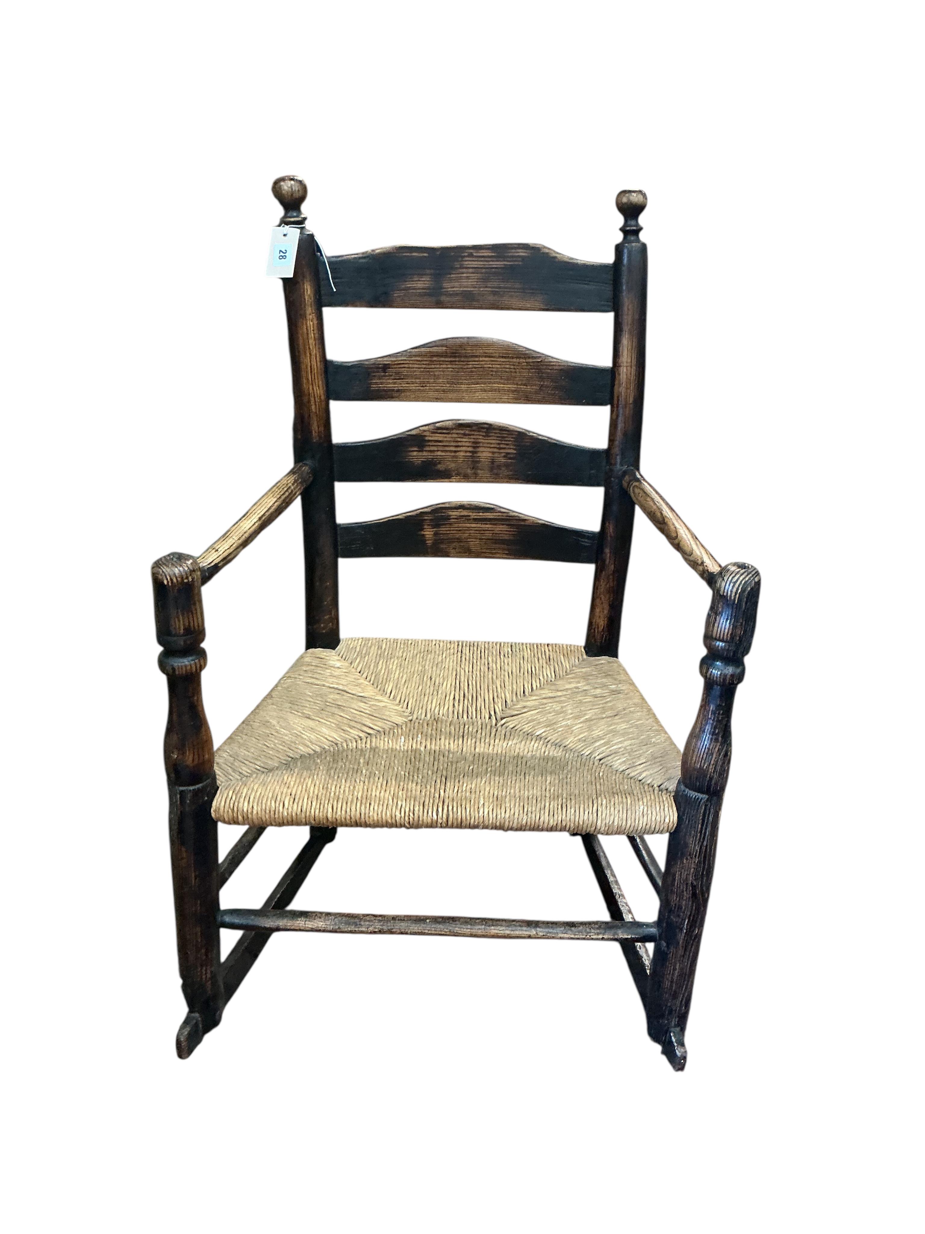 An early 19th century Provincial ash rush seat ladderback rocking chair, width 64cm, depth 41cm, height 95cm